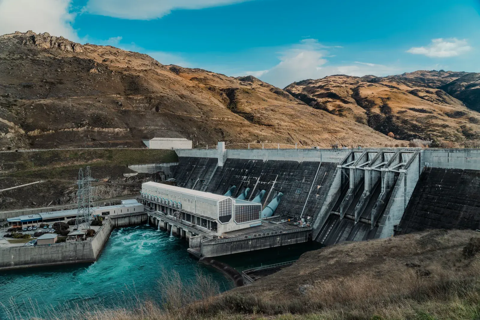 A hydroelectric dam and powerhouse surrounded by hills